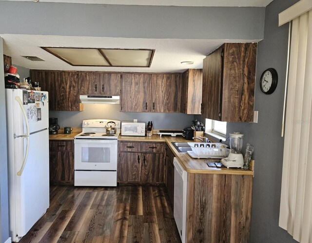 1174 Victoria Ave, Port Charlotte, FL 33948 - kitchen with under cabinet range hood, a sink, dark wood-style floors, white appliances, and light countertops