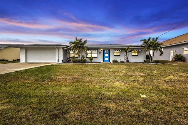 ranch-style home with a garage and a lawn