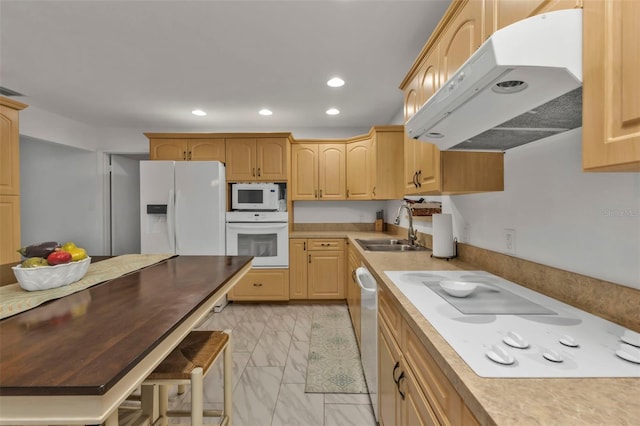 kitchen with white appliances, sink, and light brown cabinets