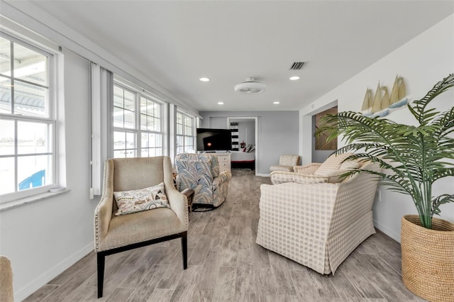 living room with light hardwood / wood-style floors and a healthy amount of sunlight