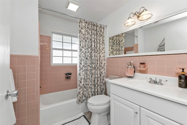 full bathroom featuring tile walls, vanity, toilet, and shower / bath combo