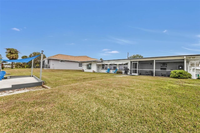 rear view of house with a sunroom and a lawn