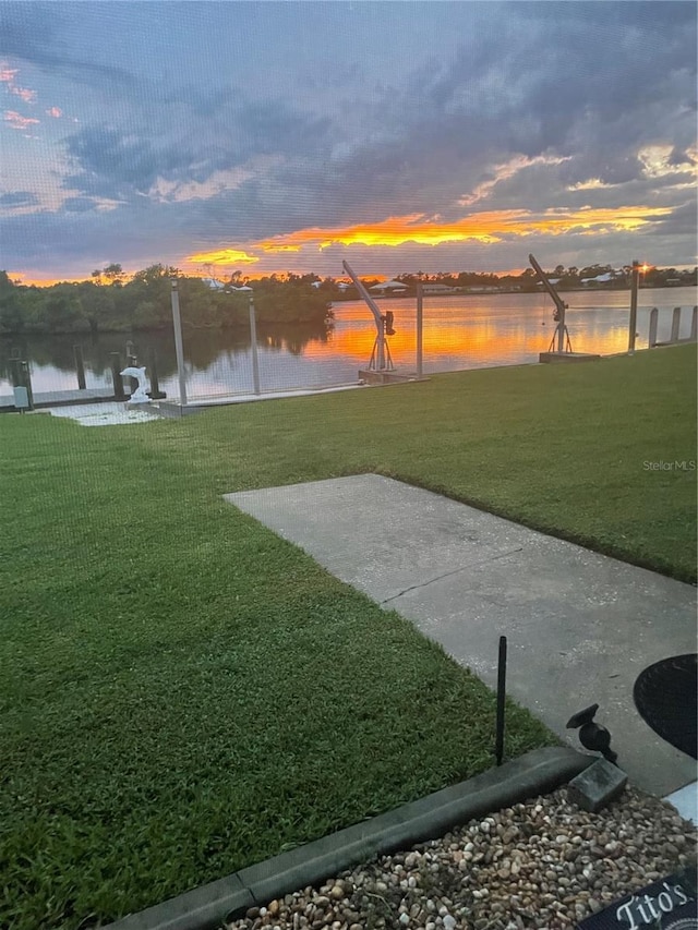 view of property's community with a water view and a yard