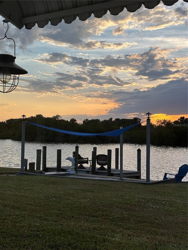 dock area with a water view and a lawn