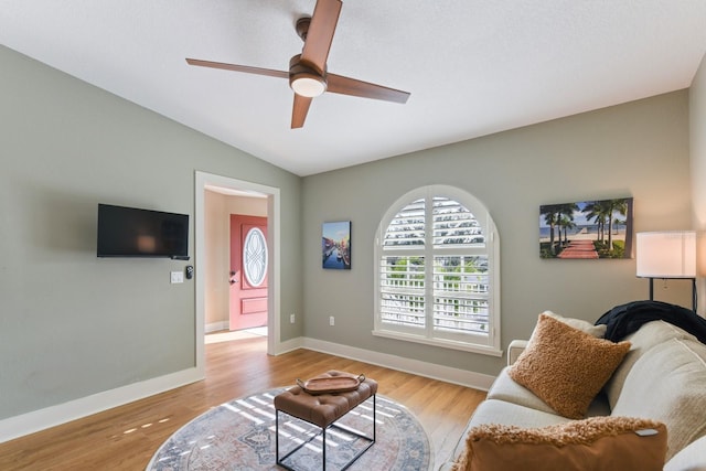 living room with vaulted ceiling, ceiling fan, and light wood-type flooring