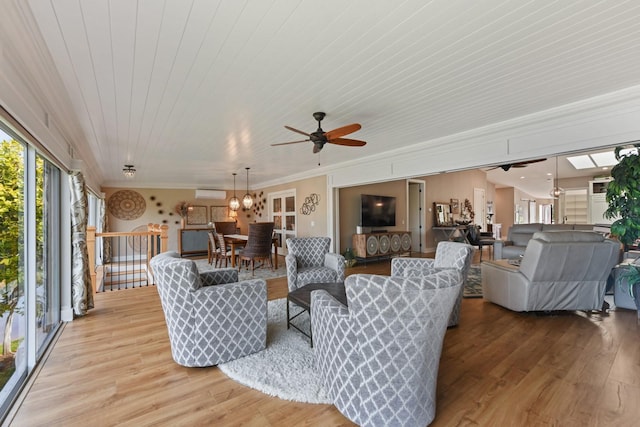 living room featuring crown molding, ceiling fan, a wall unit AC, light hardwood / wood-style floors, and wooden ceiling