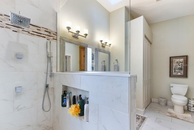 bathroom with toilet and a tile shower