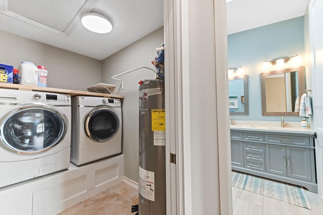 washroom featuring light tile patterned floors, sink, washing machine and dryer, and electric water heater