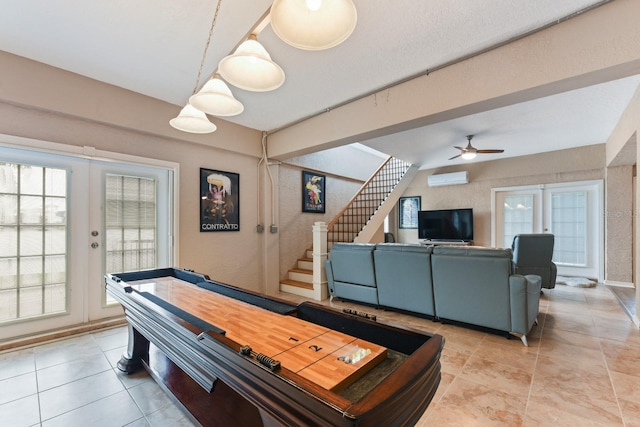 playroom with french doors, ceiling fan, a wall mounted AC, and light tile patterned flooring