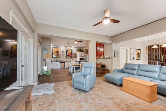 tiled living room featuring ceiling fan