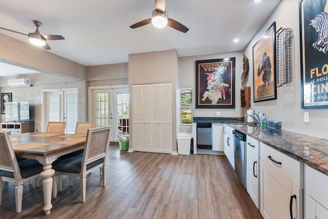 dining room with sink, hardwood / wood-style flooring, ceiling fan, french doors, and an AC wall unit