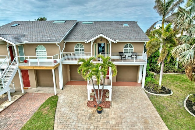 coastal inspired home featuring a front yard and a garage