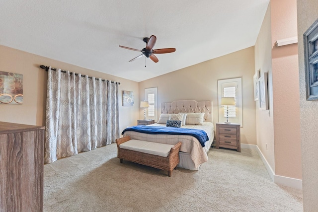 carpeted bedroom with a textured ceiling, vaulted ceiling, and ceiling fan