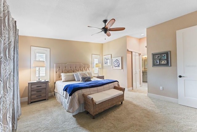 carpeted bedroom featuring ceiling fan, ensuite bath, and a textured ceiling