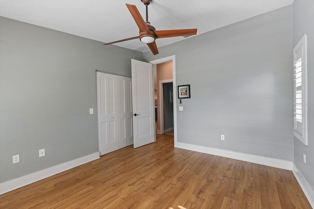 unfurnished bedroom featuring ceiling fan, a closet, and light hardwood / wood-style flooring