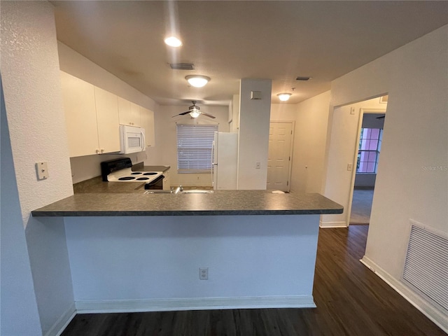 kitchen with white appliances, white cabinetry, dark hardwood / wood-style flooring, kitchen peninsula, and ceiling fan