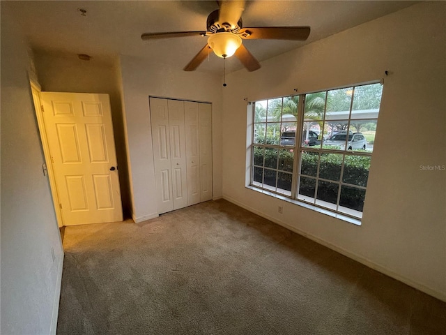 unfurnished bedroom featuring a closet, light colored carpet, and ceiling fan