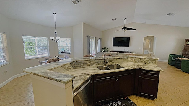 kitchen featuring lofted ceiling, sink, hanging light fixtures, light stone counters, and ceiling fan with notable chandelier