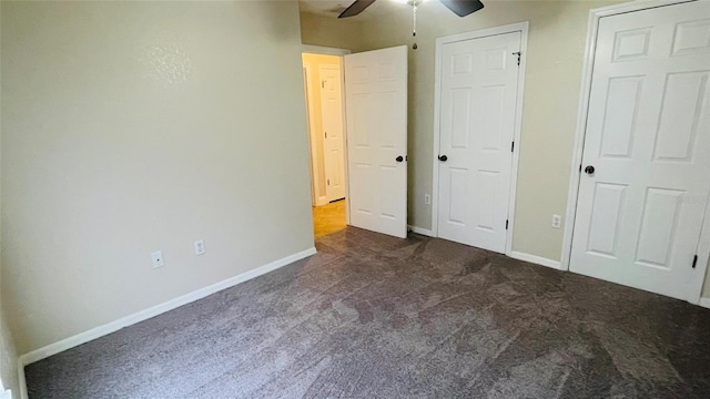 unfurnished bedroom with ceiling fan and dark colored carpet