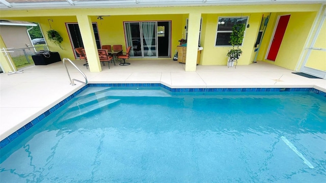 view of swimming pool featuring ceiling fan and a patio area