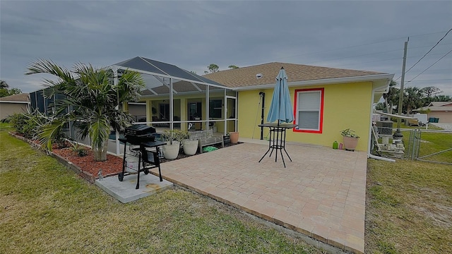 rear view of house featuring a patio area, a lawn, and glass enclosure