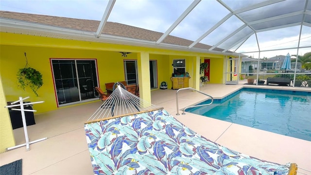 view of pool with glass enclosure and a patio area