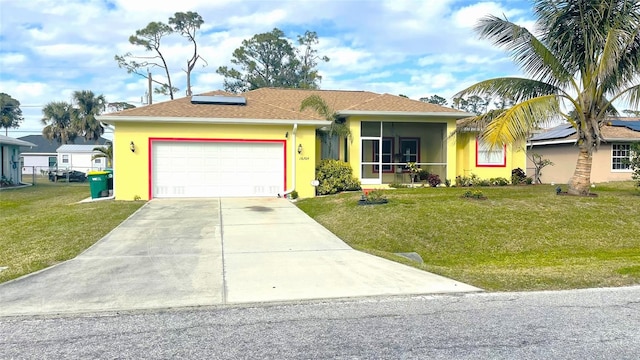 single story home with a garage, a sunroom, a front yard, and solar panels