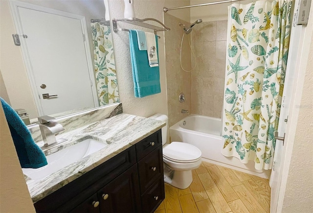 full bathroom featuring hardwood / wood-style flooring, shower / tub combo with curtain, vanity, and toilet