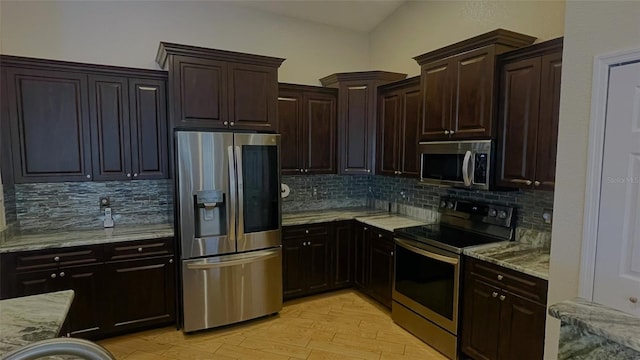 kitchen featuring tasteful backsplash, light stone countertops, appliances with stainless steel finishes, and light hardwood / wood-style floors