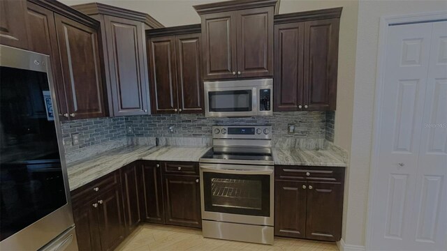 kitchen featuring decorative backsplash, dark brown cabinets, light stone countertops, and appliances with stainless steel finishes