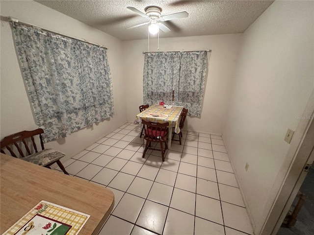 dining room with ceiling fan, a textured ceiling, and light tile patterned floors