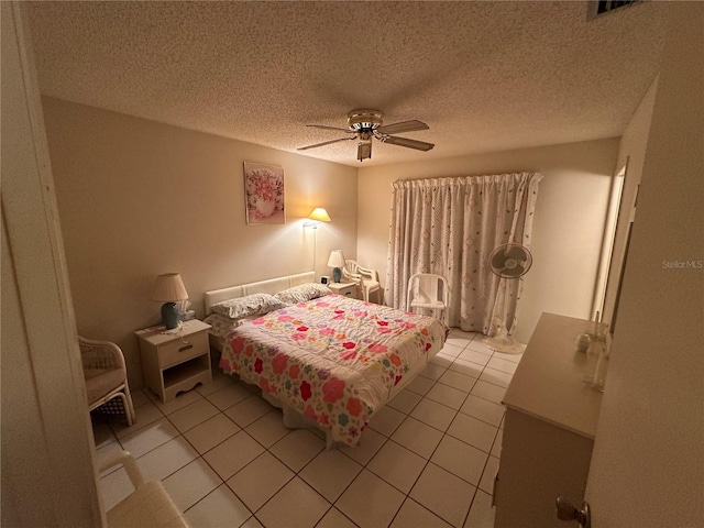 tiled bedroom with a textured ceiling and ceiling fan