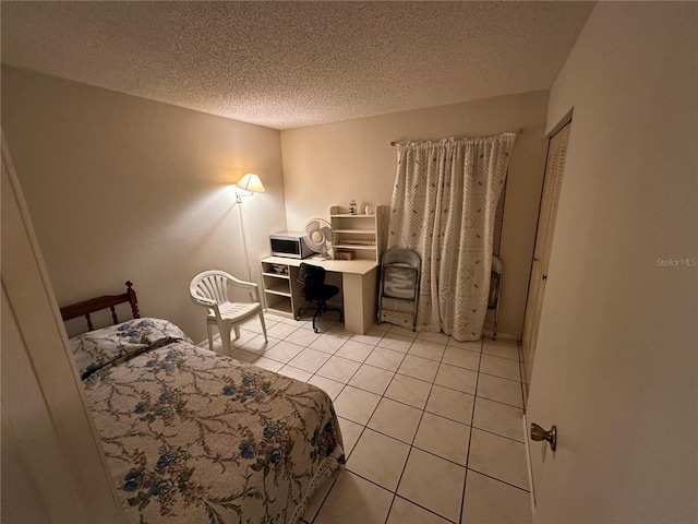 tiled bedroom with a closet and a textured ceiling