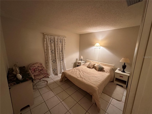 bedroom with light tile patterned floors and a textured ceiling