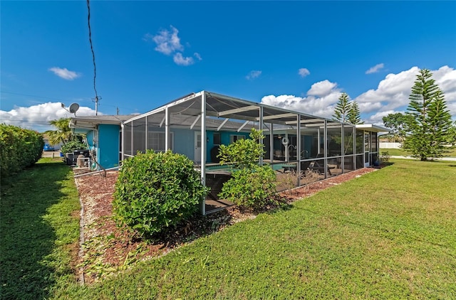 back of property with a lanai and a yard