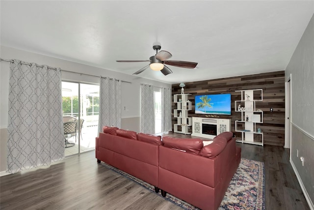 living room featuring ceiling fan, wooden walls, and wood-type flooring