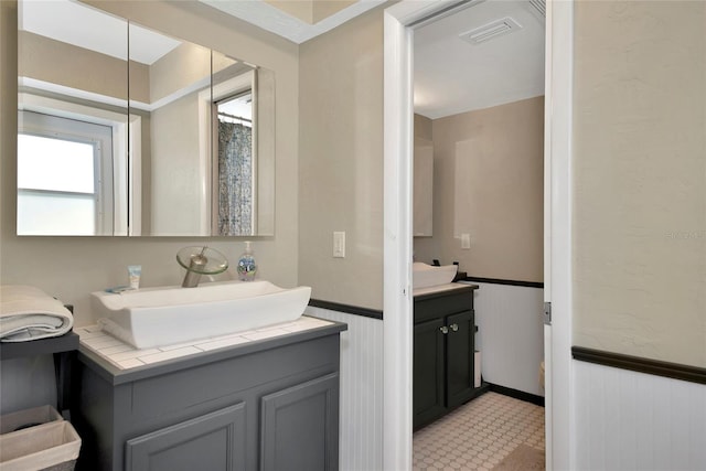 bathroom featuring vanity and wood walls