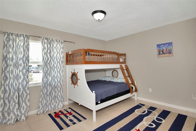 bedroom featuring tile patterned floors, a textured ceiling, and multiple windows