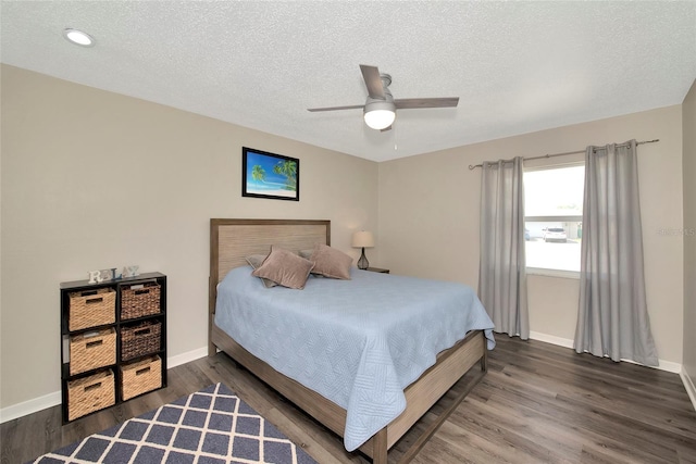 bedroom with ceiling fan, hardwood / wood-style floors, and a textured ceiling