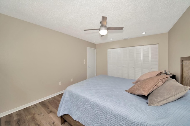 bedroom featuring a closet, ceiling fan, light hardwood / wood-style floors, and a textured ceiling