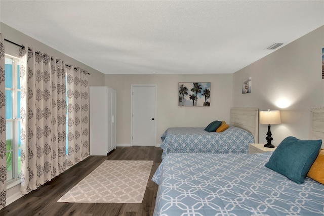 bedroom with dark wood-type flooring and a textured ceiling