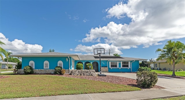 view of front of house featuring a front yard, driveway, and stucco siding
