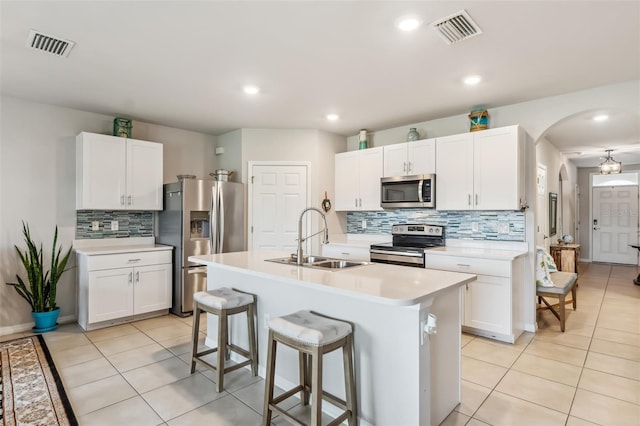 kitchen featuring sink, stainless steel appliances, white cabinets, and a kitchen island with sink