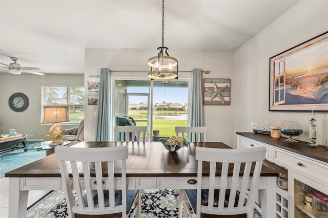 dining space with ceiling fan and tile patterned flooring