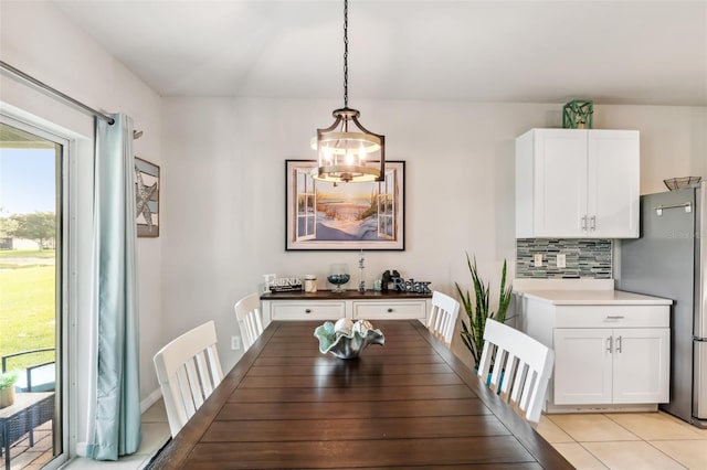 tiled dining room with an inviting chandelier