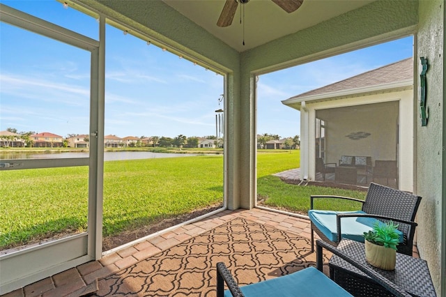 sunroom / solarium with a water view and ceiling fan