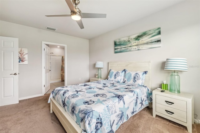 carpeted bedroom with ensuite bath and ceiling fan