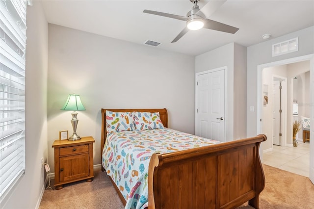 carpeted bedroom with ceiling fan and multiple windows