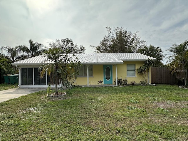 single story home featuring a sunroom and a front lawn