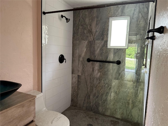 bathroom featuring a tile shower and toilet